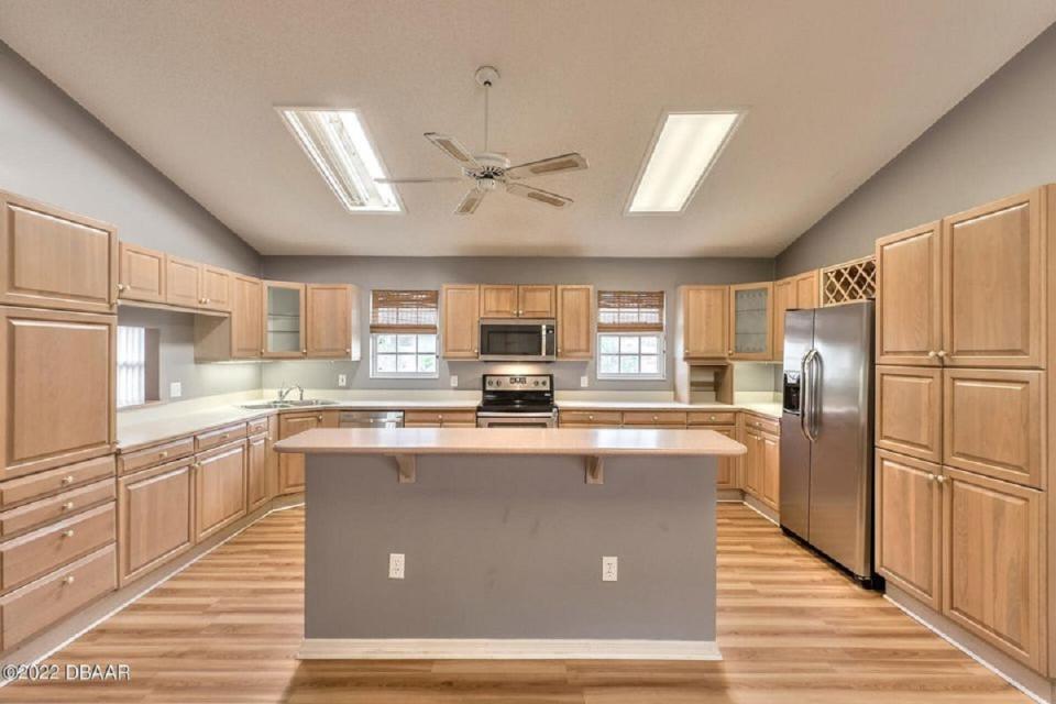 This extra spacious updated kitchen has lots of cabinets and counter space, a center island and stainless-steel appliance.