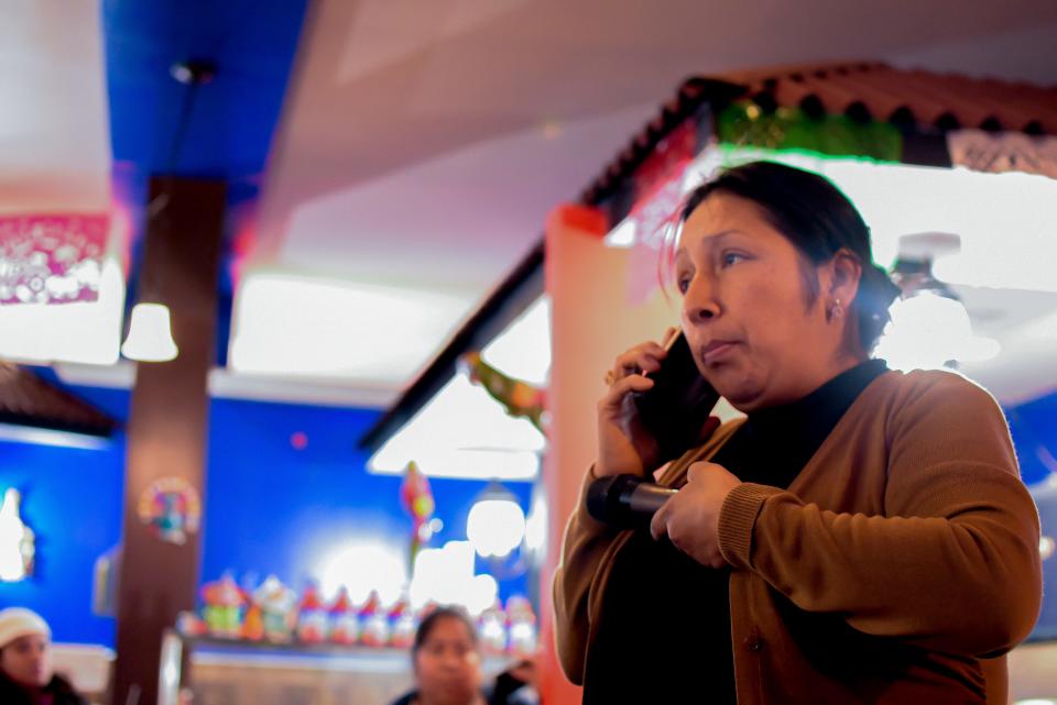 Voz Latina leader Alejandra Morales speaks with school board board attorney Michael Inzelbuch while holding a microphone close to the phone so the crowd can listen.
(Photo: Juan Carlos Castillo)