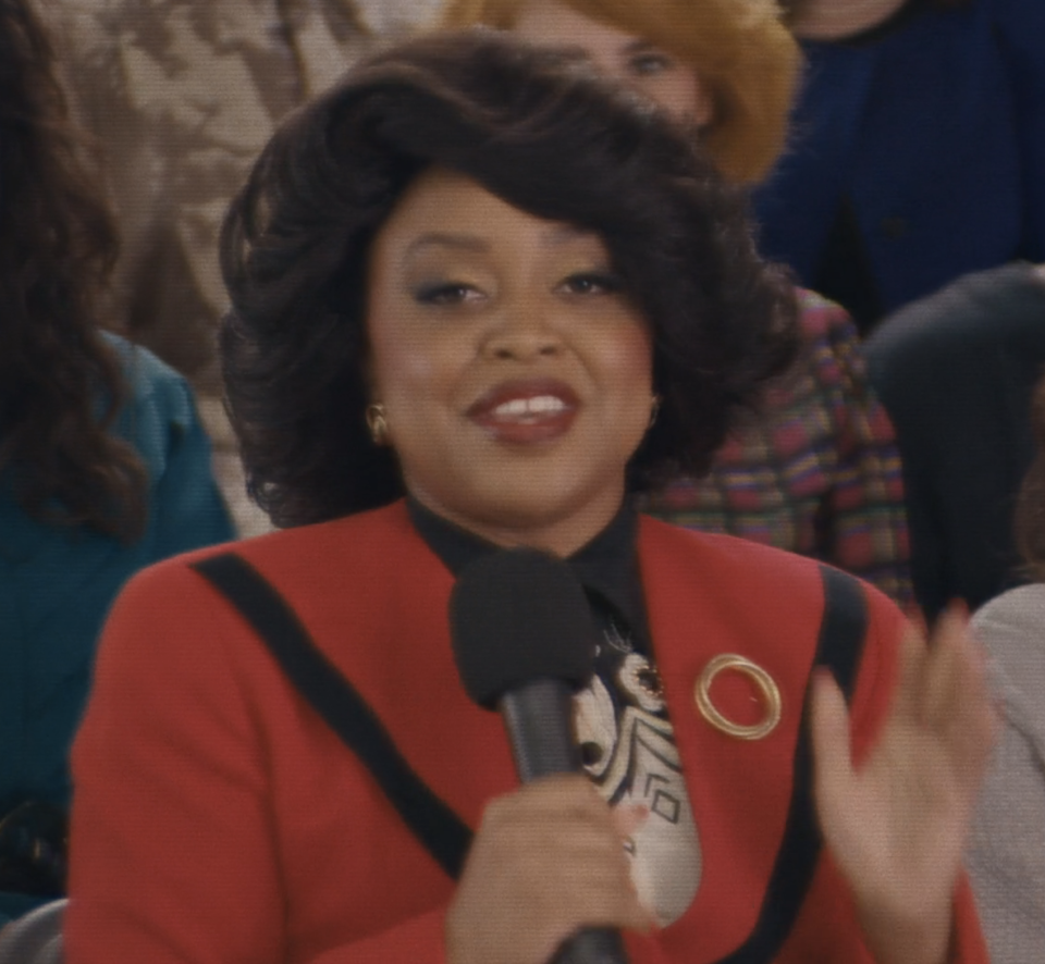 Quinta as Oprah holding a mic