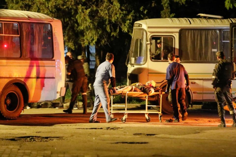 A wounded service member of Ukrainian forces from the besieged Azovstal steel mill in Mariupol is transported on a stretcher out of a bus, which arrived under escort of the pro-Russian military (REUTERS)