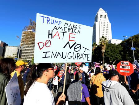 Protesters hold up signs during a march and rally against the United States President-elect Donald Trump in Los Angeles, California, U.S. December 18, 2016.REUTERS/Kevork Djansezian