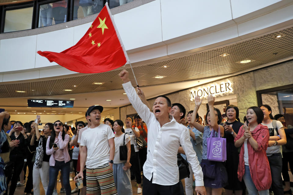 Pro-China supporters wave a Chinese national flag in a shopping mall in Hong Kong, Wednesday, Sept. 18, 2019. Activists involved in the pro-democracy protests in Hong Kong appealed to U.S. lawmakers Tuesday to support their fight by banning the export of American police equipment that is used against demonstrators and by more closely monitoring Chinese efforts to undermine civil liberties in the city. (AP Photo/Kin Cheung)