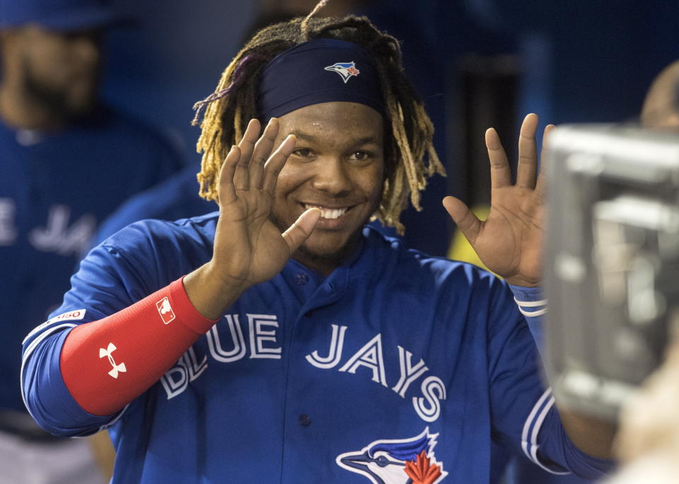 Toronto Blue Jays' Vladimir Guerrero Jr. smiles for a television camera looking into the dugout in the sixth inning of a baseball game against the Oakland Athletics in Toronto, Saturday April 27, 2019. (Fred Thornhill/The Canadian Press via AP)