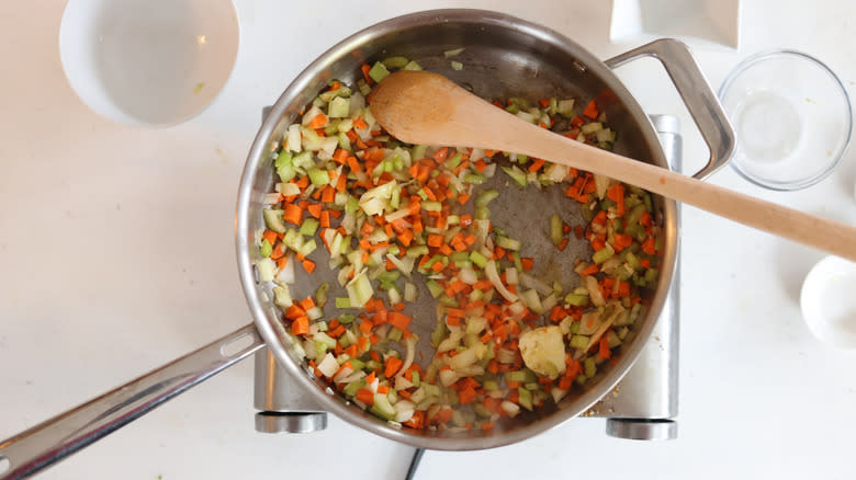 softened vegetables in pan with wooden spoon