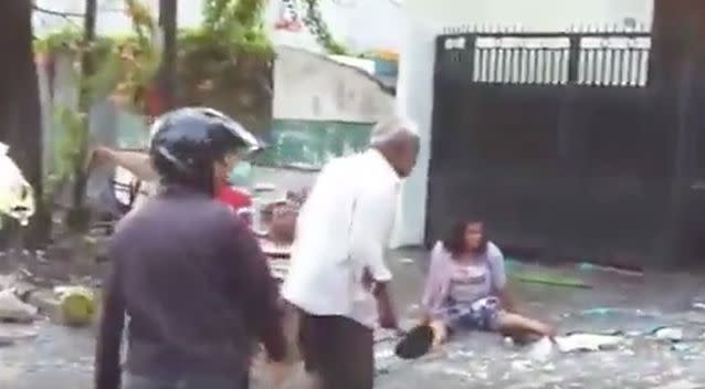 A man in the street is seen trying to help an injured lady. Photo: YouTube