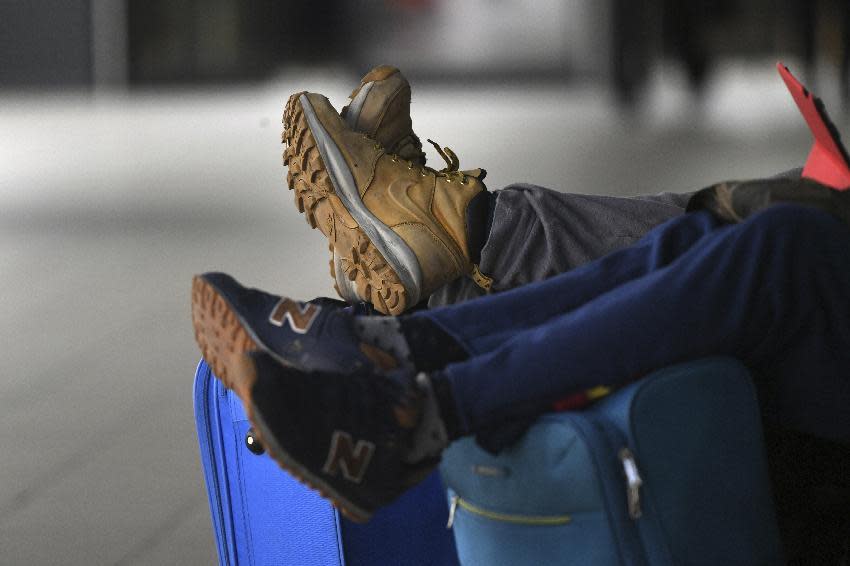 Travelers wait at Schoenefeld airport outside Berlin, Germany, Monday, March 13, 2017. Ground staff at Berlin's two airports went on strike Monday for the second time in four days, forcing the cancellation of hundreds of flights. (Ralf Hirschberger/dpa via AP)