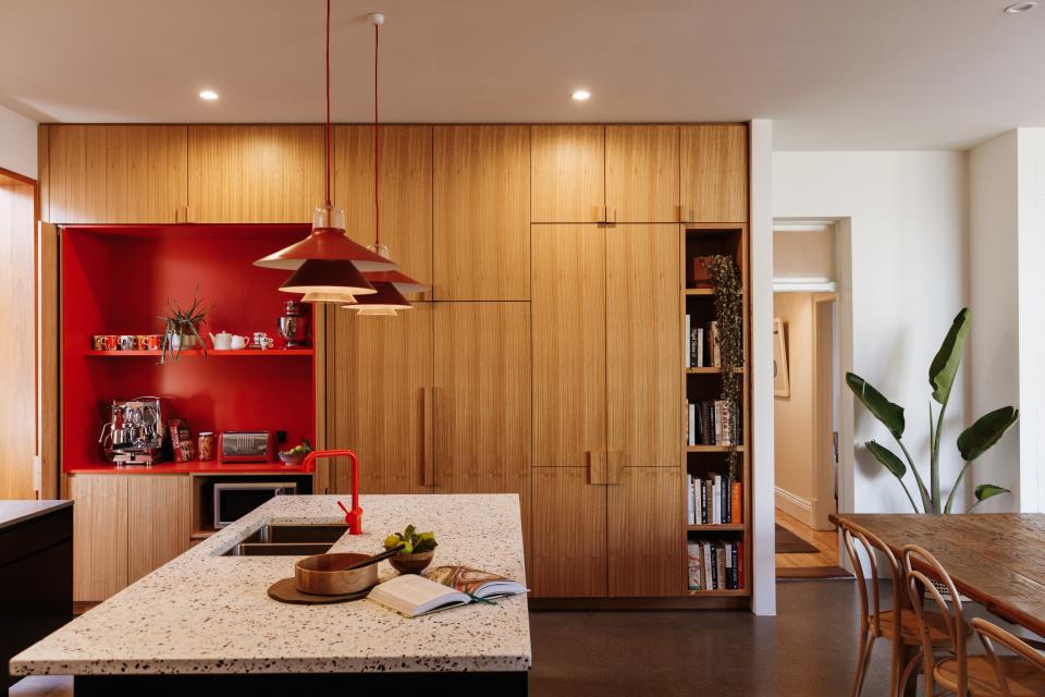 As the statement wall in the kitchen, this area epitomizes the home’s high-energy palette thanks to its wood pantry and red appliance nook. “It’s a space you want to spend time in,” Kate says.