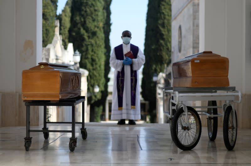 FILE PHOTO: Coffins of two victims of coronavirus disease (COVID-19) are seen during a burial ceremony in the southern town of Cisternino, Italy