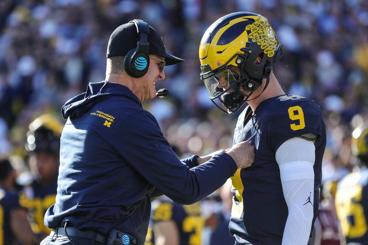 Michigan coach Jim Harbaugh talks to quarterback J.J. McCarthy before the first half of the Rose Bowl in Pasadena, California, on Monday, Jan. 1, 2024.