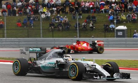 Mercedes Formula One driver Lewis Hamilton of Britain powers out of a turn ahead of Ferrari Formula One driver Sebastian Vettel of Germany during the U.S. F1 Grand Prix at the Circuit of The Americas in Austin, Texas October 25, 2015. REUTERS/Mike Stone