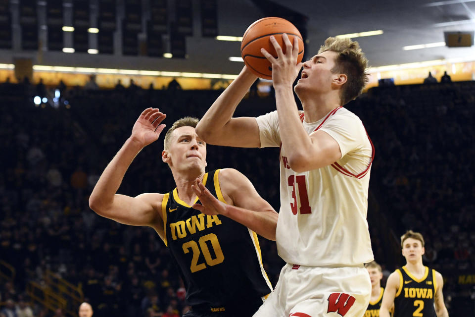 Wisconsin forward Nolan Winter (31) takes a shot under pressure from Iowa forward Payton Sandfort (20) during the first half of an NCAA college basketball game, Saturday, Feb. 17, 2024, in Iowa City, Iowa. (AP Photo/Cliff Jette)