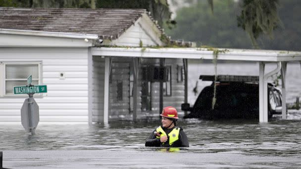 PHOTO: A first responder with Orange County Fire Rescue makes her way through floodwaters looking for residents of a neighborhood needing help in the aftermath of Hurricane Ian in Orlando, FLa., Sept. 29, 2022. (Phelan M. Ebenhack/AP)