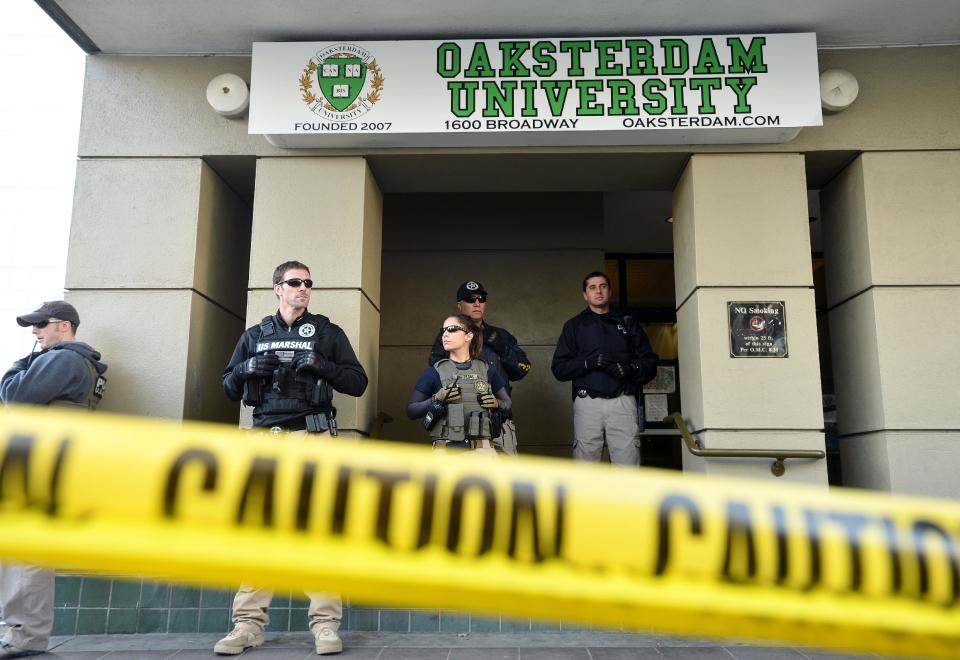 U.S. marshals stand at the entrance of Oaksterdam University in Oakland, Calif., on Monday, April 2, 2012. The federal agents raided the medical marijuana training school at the heart of California's pot legalization movement. (AP Photo/Noah Berger)