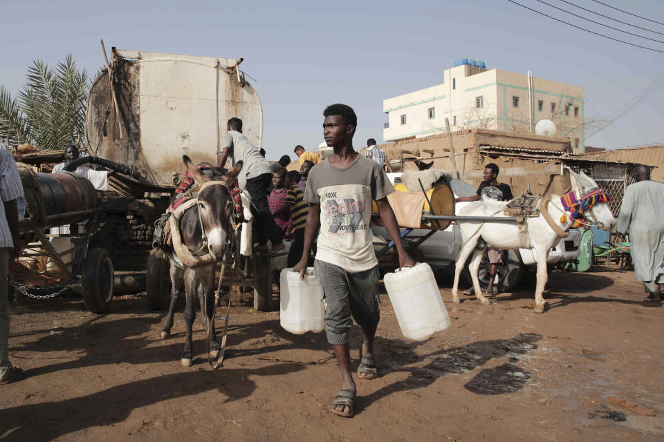 People gather to collect water in Khartoum, Sudan, Sunday, May 28, 2023. The Sudanese army and a rival paramilitary force, battling for control of Sudan since mid-April, had agreed last week to the weeklong truce, brokered by the U.S. and the Saudis. However, the cease-fire, like others before it, did not stop the fighting in the capital of Khartoum and elsewhere in the country. (AP Photo/Marwan Ali)