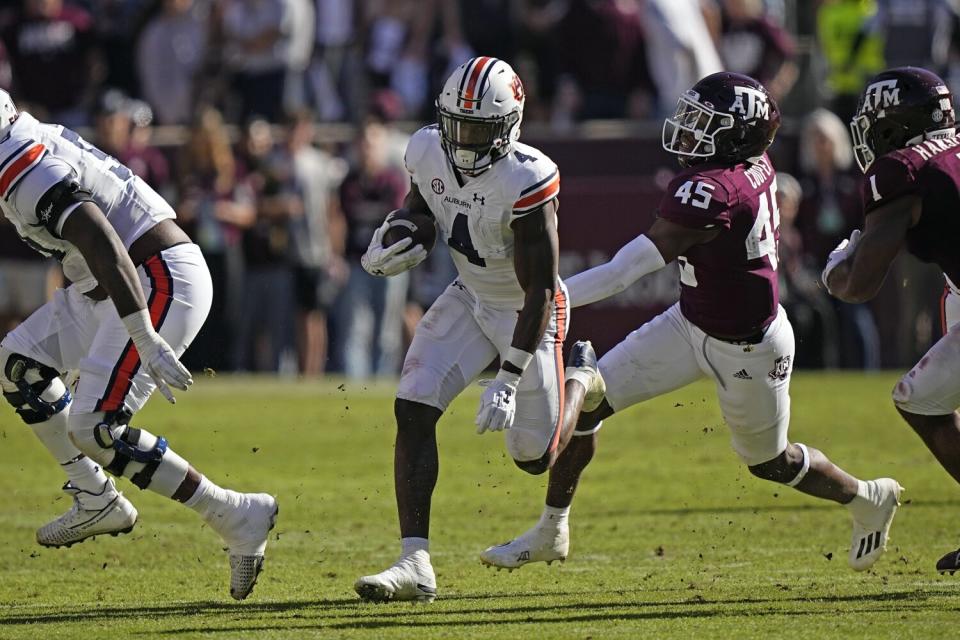 Auburn running back Tank Bigsby carries the ball in front of Texas A&M linebacker Edgerrin Cooper on Nov. 6.