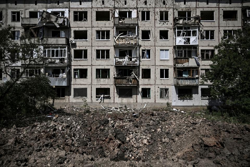 TOPSHOT - A picture shows a crater in front of a damaged apartment building after a missile strike in the city of Soledar, in the eastern Ukrainian region of Donbas on June 4, 2022. - Russian artillery is slamming Ukraine's eastern Donbas region with fierce fighting over the city of Severodonetsk, but the local governor says there was some progress in pushing back invading forces. (Photo by ARIS MESSINIS / AFP) (Photo by ARIS MESSINIS/AFP via Getty Images)