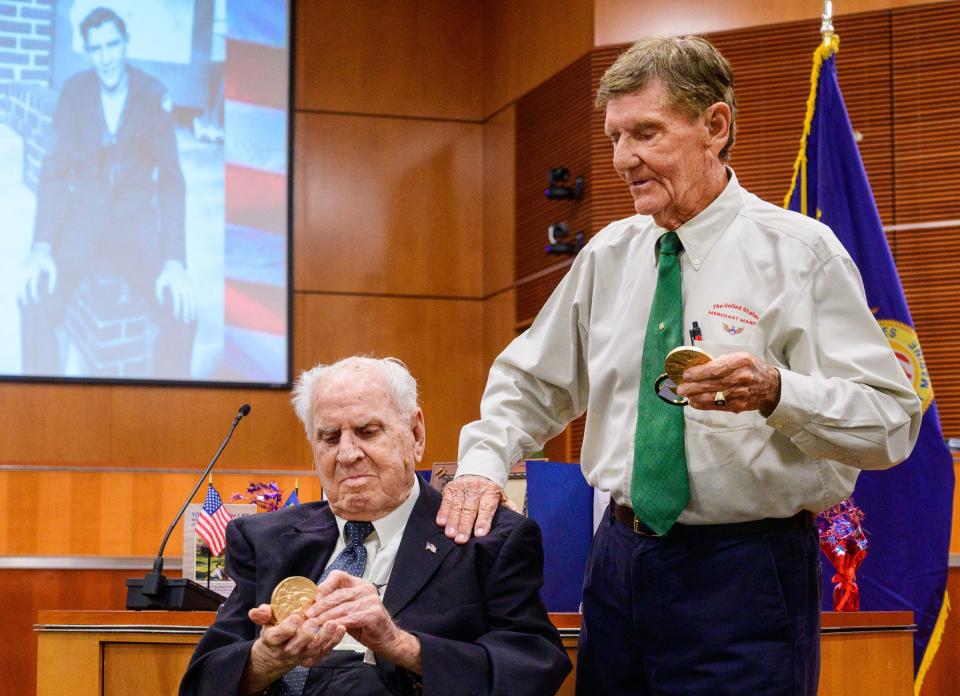 Ed Trester, 95, puts his hand on the shoulder of Bill Pruitt, 102, after U.S. Congressman Mike Waltz presented them with Congressional Gold Medals for their service in the U.S. Merchant Marine during World War II at a ceremony at the St. Johns County Administration building in St. Augustine on Thursday, June 30, 2022.