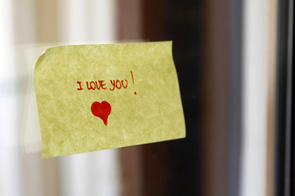 Sticky note on a surface with "I love you!" handwritten and a small heart drawn below the text