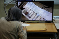 A candidate representative watches a screen displaying ballots after the close of a polling station at the end of the parliamentary election day, in Beirut, Lebanon, Sunday, May 15, 2022. Lebanese voted for a new parliament Sunday against the backdrop of an economic meltdown that is transforming the country and low expectations that the election would significantly alter the political landscape. (AP Photo/Hussein Malla)