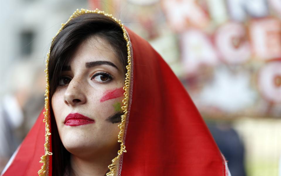 An activist wears a Syrian flag during an event organised by Stop the War Coalition to protest against potential UK involvement in the Syrian conflict in Whitehall, London.