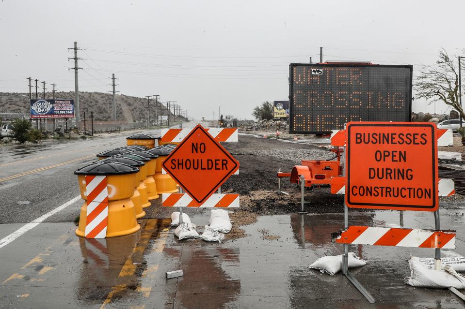 Signs warn travelers of a water crossing ahead on Indian Canyon Dr. which was closed by heavy rains in Palm Springs, Calif., Feb. 5, 2024.