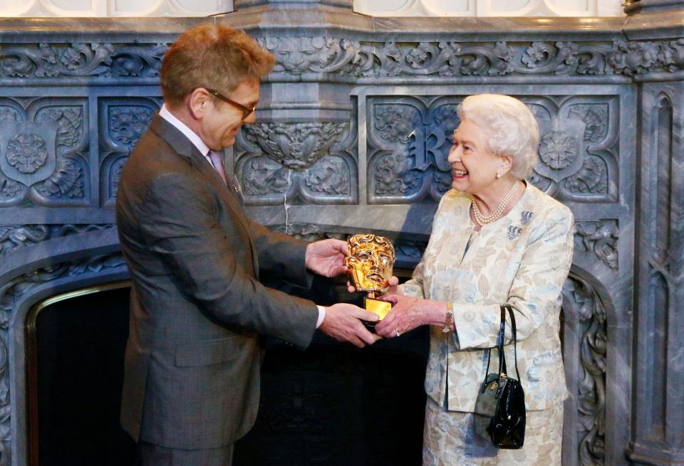 <p>The Queen receives an honorary Bafta from actor and director Kenneth Branagh in recognition of a lifetime's support of British film and television at Windsor Castle in Windsor on 4 April 2013. (AFP via Getty Images)</p> 