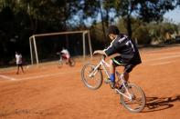 A child rides on a bike in a soccer field in the neighbourhood of Estrutural in Brasilia