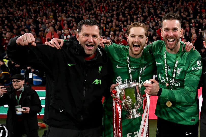 Liverpool head of goalkeeper John Achterberg celebrates alongside Caoimhin Kelleher and Adrian with the Carabao Cup trophy at the end of the final against Chelsea at Wembley on February 25 2024