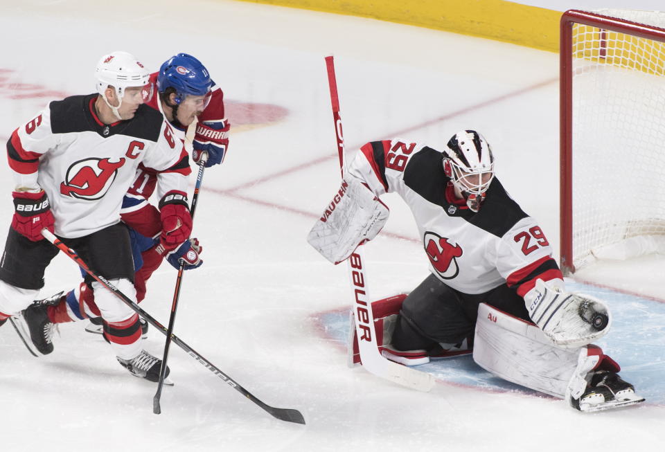 Montreal Canadiens' Brendan Gallagher (11) moves in against New Jersey Devils goaltender Mackenzie Blackwood as Devils' Andy Greene (6) defends during second-period NHL hockey game action in Montreal, Thursday, Nov. 28, 2019. (Graham Hughes/The Canadian Press via AP)