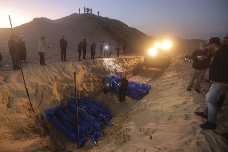 Palestinians bury the bodies of 80 victims, killed in the north of the Gaza Strip, at a mass grave in the city of Rafah. Israeli army delivered the bodies this evening through the Kerem Shalom crossing, amid ongoing battles between Israel and the Palestinian Hamas movement. Mohammed Talatene/dpa