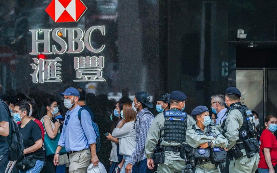 Riot police stand guard in front of an HSBC Holdings