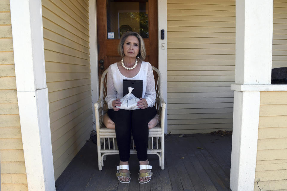 Abby Swoveland sits with what the Return to Nature Funeral Home said were her mother's ashes in Colorado Springs, Colo., on Thursday, Oct. 19, 2023. The Penrose, Colo., funeral home where nearly 200 decaying bodies were discovered this month appears to have fabricated cremation records and may have given families fake ashes, according to information gathered by The Associated Press from customers and crematories. (AP Photo/Thomas Peipert)