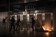 Demonstrators damage the Barcelona Stock Exchange building during a protest condemning the arrest of rap singer Pablo Hasel in Barcelona, Spain, Saturday, Feb. 20, 2021. The imprisonment of Pablo Hasel for inciting terrorism and refusing to pay a fine after having insulted the country's monarch has triggered a social debate and street protests. (AP Photo/Felipe Dana)