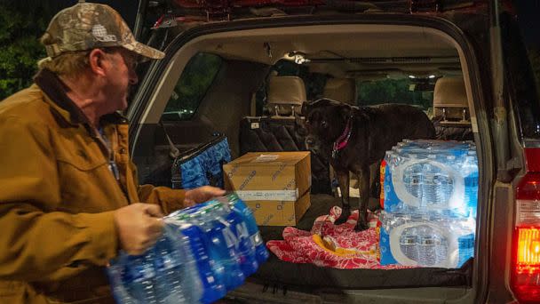 PHOTO: John Beezley, of Bonham, loads several cases of water after learning that a boil water notice was issued for the entire city of Houston, Nov. 27, 2022. (Mark Mulligan/Houston Chronicle via AP)