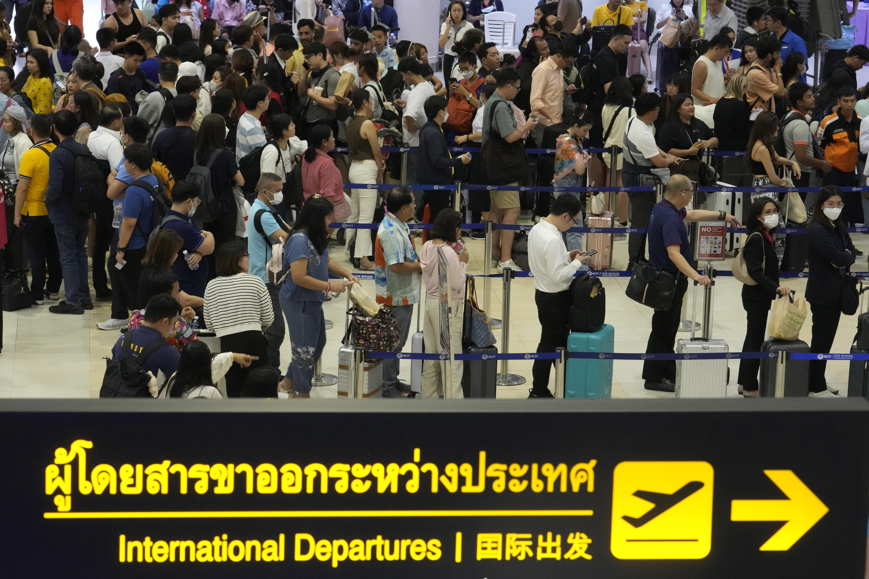 Passengers wait to check in at Bangkok's Don Mueang International Airport.