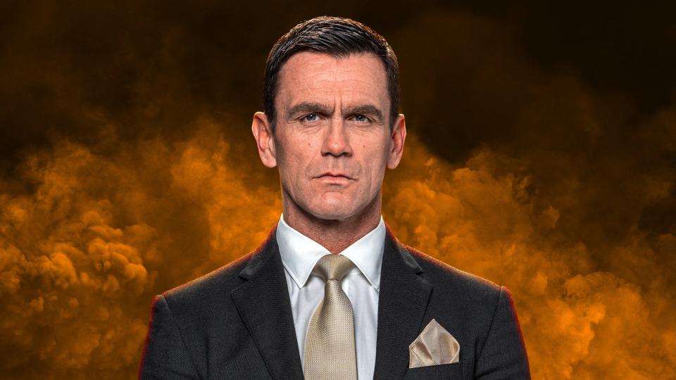 Jack Branning wearing a suit surrounded by yellow smoke.