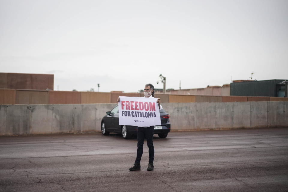 Jordi Cuixart, one of the Catalan leaders imprisoned for their role in the 2017 push for an independent Catalan republic, holds a banner at Lledoners prison in Sant Joan de Vilatorrada, near Barcelona, Spain, Wednesday, June 23, 2021. Nine separatists pardoned by the Spanish government are expected to leave the prisons where they were serving lengthy terms for organizing a bid for an independent northeastern Catalonia region nearly four years ago. Spain's official gazette published earlier in the day the government decree pardoning them. (AP Photo/Joan Mateu)