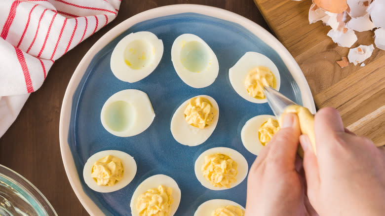 Person piping deviled eggs