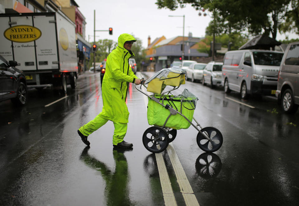 This postal worker was seen delivering letters and parcels in rain gear despite the weather. Photo: AAP