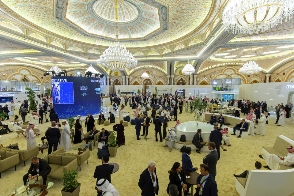 In this photo released by Future Investment Initiative, delegates meet and network in the "marketplace" ballroom at the Future Investment Initiative forum, in Riyadh, Saudi Arabia, Tuesday, Oct. 26, 2021. Saudi Arabia's crown prince wants businesses, their employees and their families to move to the kingdom. The landlocked once ultraconservative capital, Riyadh, now promises a lifestyle where concerts, movie theaters, world class sporting events and deal-making are in abundance, and where cultural heritage sites are being revamped for tourists to distinguish Saudi Arabia from other Gulf capitals defined by sprawling malls and high-rise hotels. (Future Investment Initiative via AP)