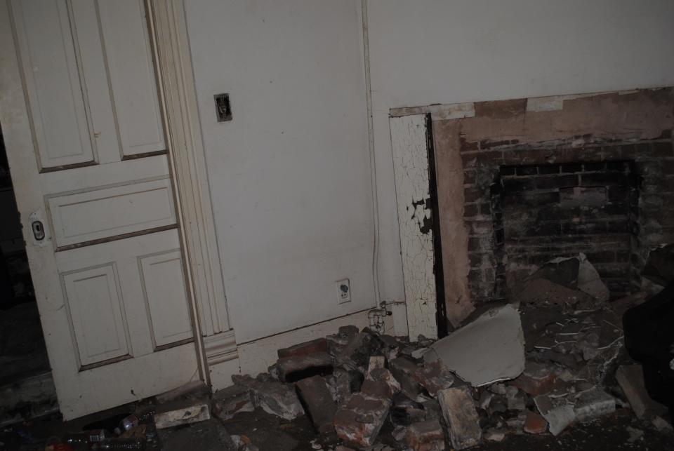 A damaged fireplace and sliding doors to the dining room show the ravages vandals have inflicted in the landmark Berry Brown house at 1400 Travis St.