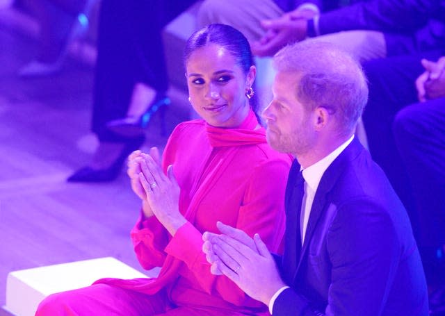 Meghan looks at Harry as they sit and applaud during a One Young World Summit in Manchester