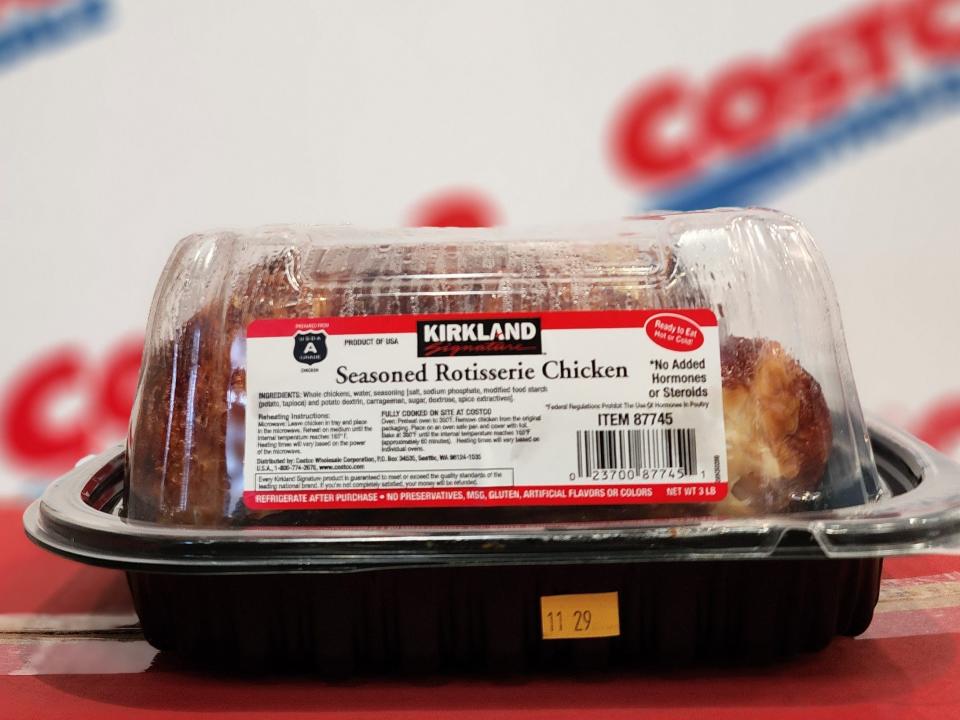 Container of Costco rotisserie chicken against a background with "Costco" on it