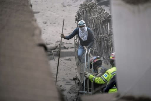 A local resident and rescuers search for victims in San Miguel Los Lotes, a village in Escuintla Department, about 35 km southwest of Guatemala City, on June 4, 2018, a day after the eruption of the Fuego Volcano