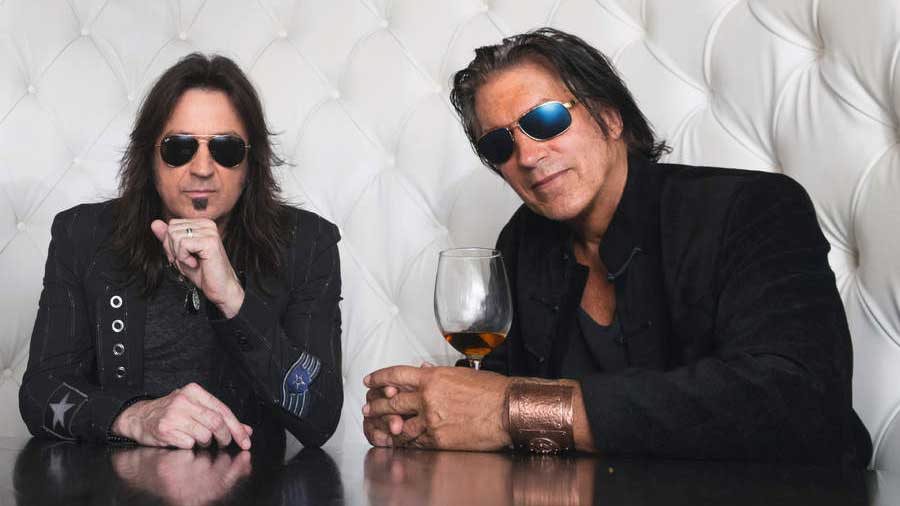  Sweet & Lynch seated at a table wearing sunglasses 