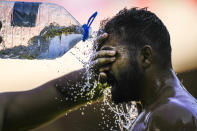 A wrestler cools off as he competes during the 661st annual Historic Kirkpinar Oil Wrestling championship, in Edirne, northwestern Turkey, Saturday, July 2, 2022. The festival is part of UNESCO's List of Intangible Cultural Heritages. (AP Photo/Francisco Seco)