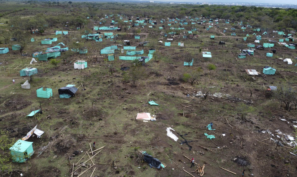 Las personas recuperan sus pertenencias luego de que la policía los desalojó de un terreno en Neiva, Colombia, el miércoles 28 de septiembre de 2022. Al menos 50 hectáreas fueron ocupadas de forma ilegal por unas 500 familias hace casi dos meses. (Foto AP/Fernando Vergara)