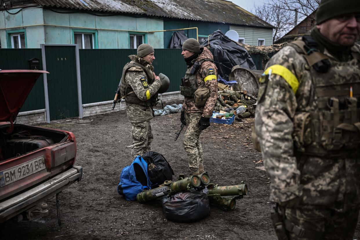 Ukrainian soldiers talk as they stand near their weapons at a frontline, northeast of Kyiv on March 3, 2022. - A Ukrainian negotiator headed for ceasefire talks with Russia said on March 3, 2022, that his objective was securing humanitarian corridors, as Russian troops advance one week into their invasion  of the Ukraine. (Photo by Aris Messinis / AFP) (Photo by ARIS MESSINIS/AFP via Getty Images)