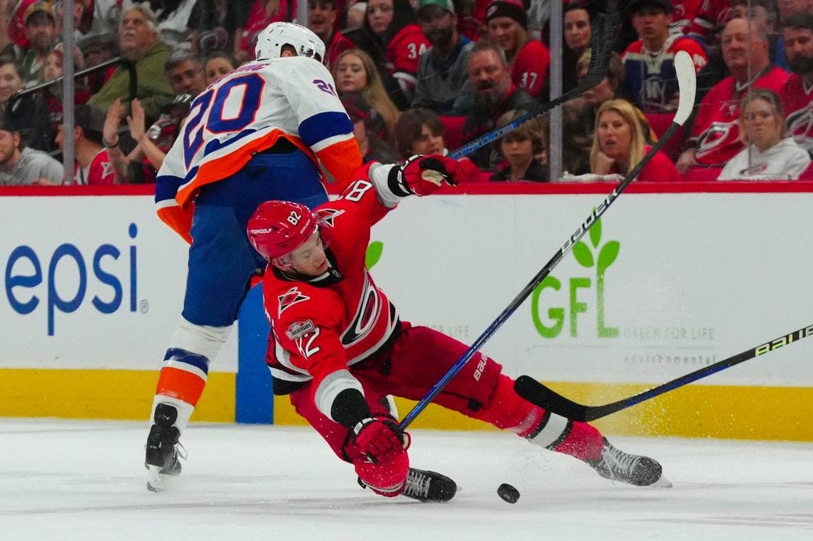 New York Islanders right wing Hudson Fasching (20) checks Carolina Hurricanes center Jesperi Kotkaniemi (82) during the second period in game two of the first round of the 2023 Stanley Cup Playoffs at PNC Arena.