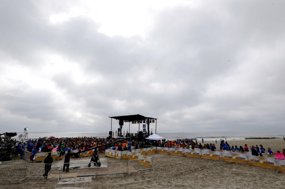 People gather around a stage as musical group Fun performs on the beach, Friday, May 24, 2013, in Seaside Heights, N.J. New Jersey Gov. Chris Christie cut a ribbon to symbolically reopen the state's shore for the summer season, seven months after being devastated by Superstorm Sandy. Several beach communities have annual beach ribbon cuttings, announcing they are back in business. But this year's ceremonies are more poignant seven months after a storm that did an estimated $37 billion of damage in the state. (AP Photo/Julio Cortez)